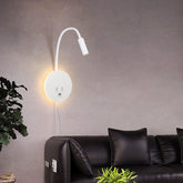 Modern wall-mounted reading light in a living room setting with a black sofa and plants.